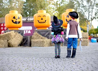 Children in front of large Pumpkin minifigure heads at Brick or Treat at the LEGOLAND Windsor Resort