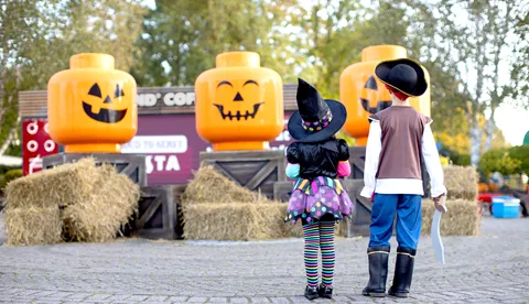 Children in front of large Pumpkin minifigure heads at Brick or Treat at the LEGOLAND Windsor Resort