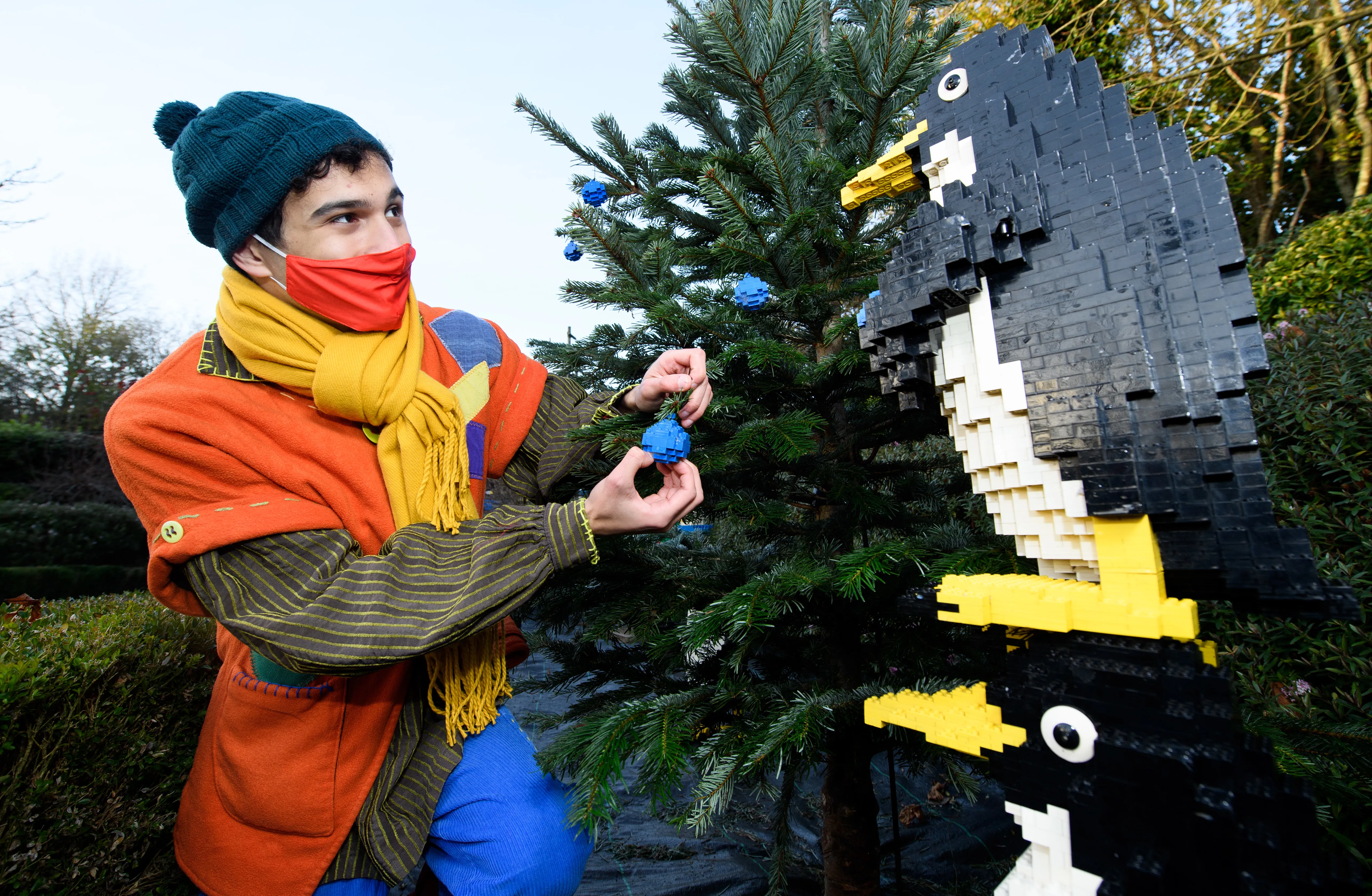 Elf hanging LEGO baubles on Christmas tree with LEGO penguins at LEGOLAND at Christmas at the LEGOLAND Windsor Resort