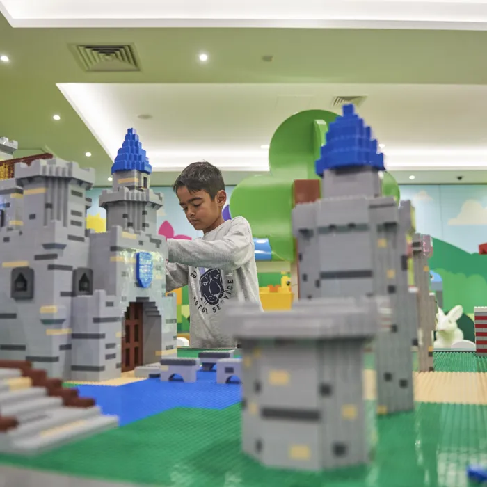 Child building around LEGO model of a castle in the LEGOLAND Playroom