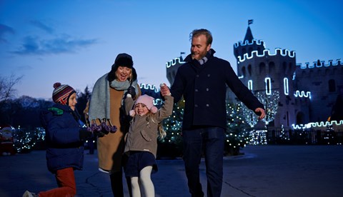 Family outside lit up castle at LEGOLAND at Christmas