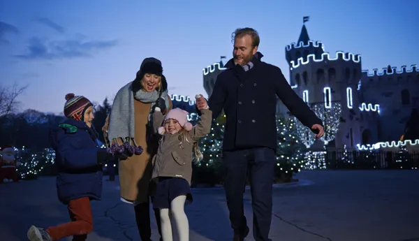 Family outside lit up castle at LEGOLAND at Christmas