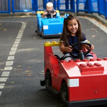 Girl and boy driving cars at L-Drivers at the LEGOLAND Windsor Resort