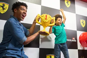 Boy and father lifting LEGO trophy at LEGO Ferrari Build & Race