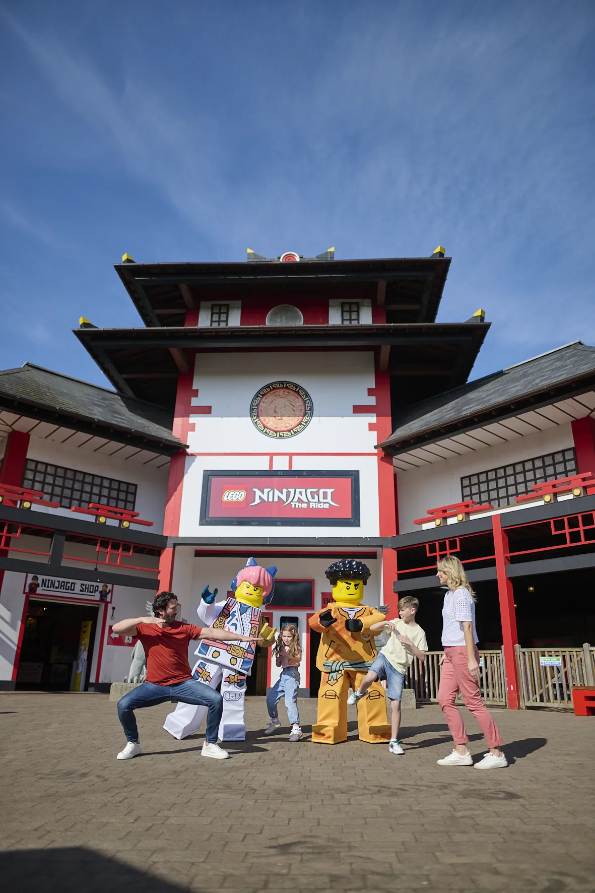 Dad, Mum and 2 children doing Ninja moves outside LEGO NINJAGO The Ride with Sora and Arin from LEGO NINJAGO