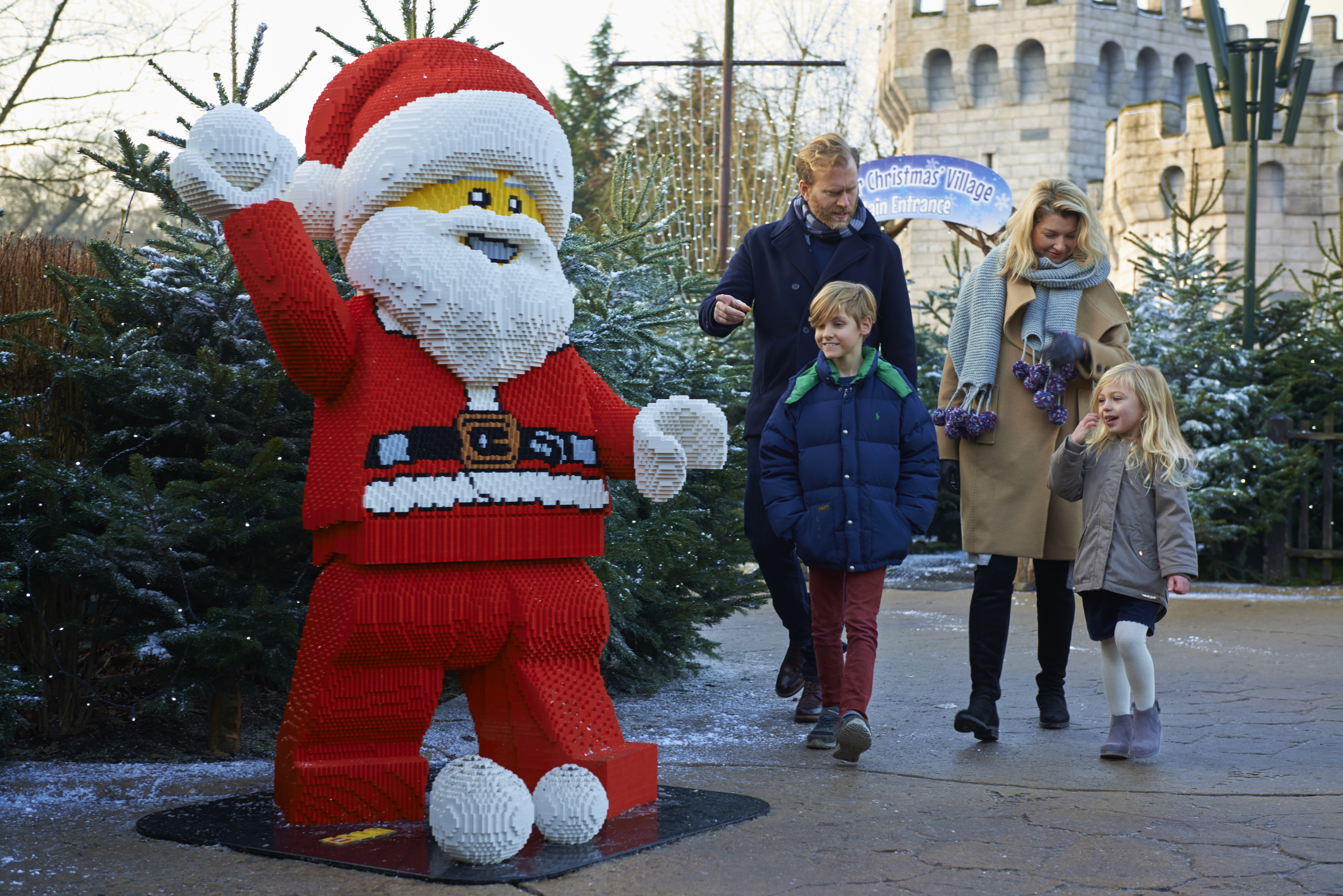 Family walking towards LEGO model of Father Christmas at LEGOLAND at Christmas