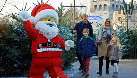 Family walking towards LEGO model of Father Christmas at LEGOLAND at Christmas