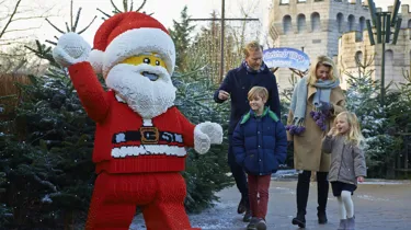 Family walking towards LEGO model of Father Christmas at LEGOLAND at Christmas