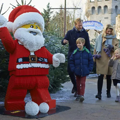 Family walking towards LEGO model of Father Christmas at LEGOLAND at Christmas