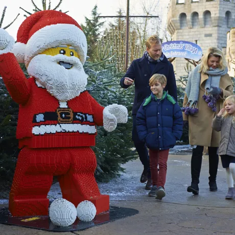 Family walking towards LEGO model of Father Christmas at LEGOLAND at Christmas