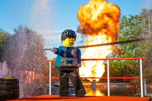 Duke DeTain, a LEGO police officer, stood in front of a fireball and a water splash
