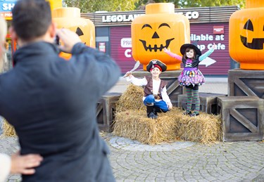 Children posing by giant LEGO minifigure pumpkin heads at Brick or Treat at LEGOLAND Windsor Resort