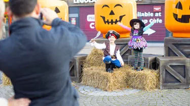 Children posing by giant LEGO minifigure pumpkin heads at Brick or Treat at LEGOLAND Windsor Resort