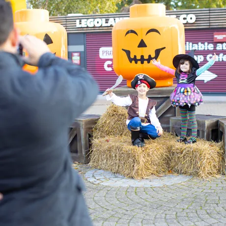 Children posing by giant LEGO minifigure pumpkin heads at Brick or Treat at LEGOLAND Windsor Resort