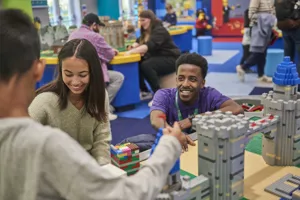 Staff member interacting with families building with LEGO in the LEGOLAND Playroom