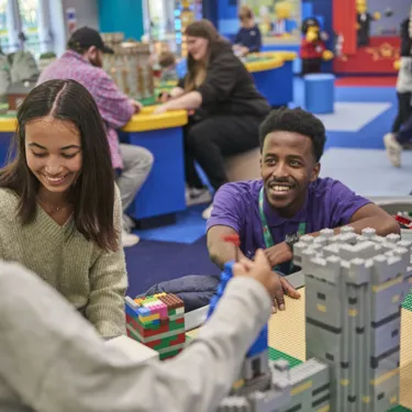 Staff member interacting with families building with LEGO in the LEGOLAND Playroom