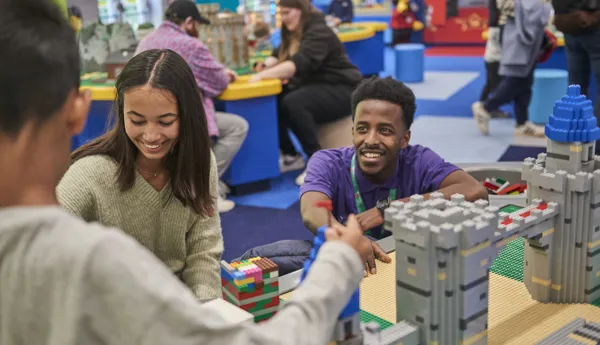 Staff member interacting with families building with LEGO in the LEGOLAND Playroom